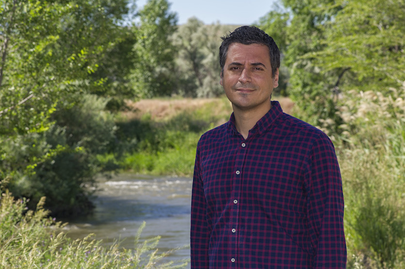 Photo of ISU Professor Antonio Castro standing near Portneuf River.