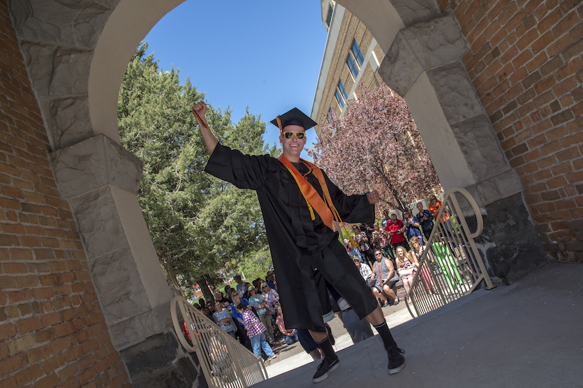 A graduate walking through Arch in 2017