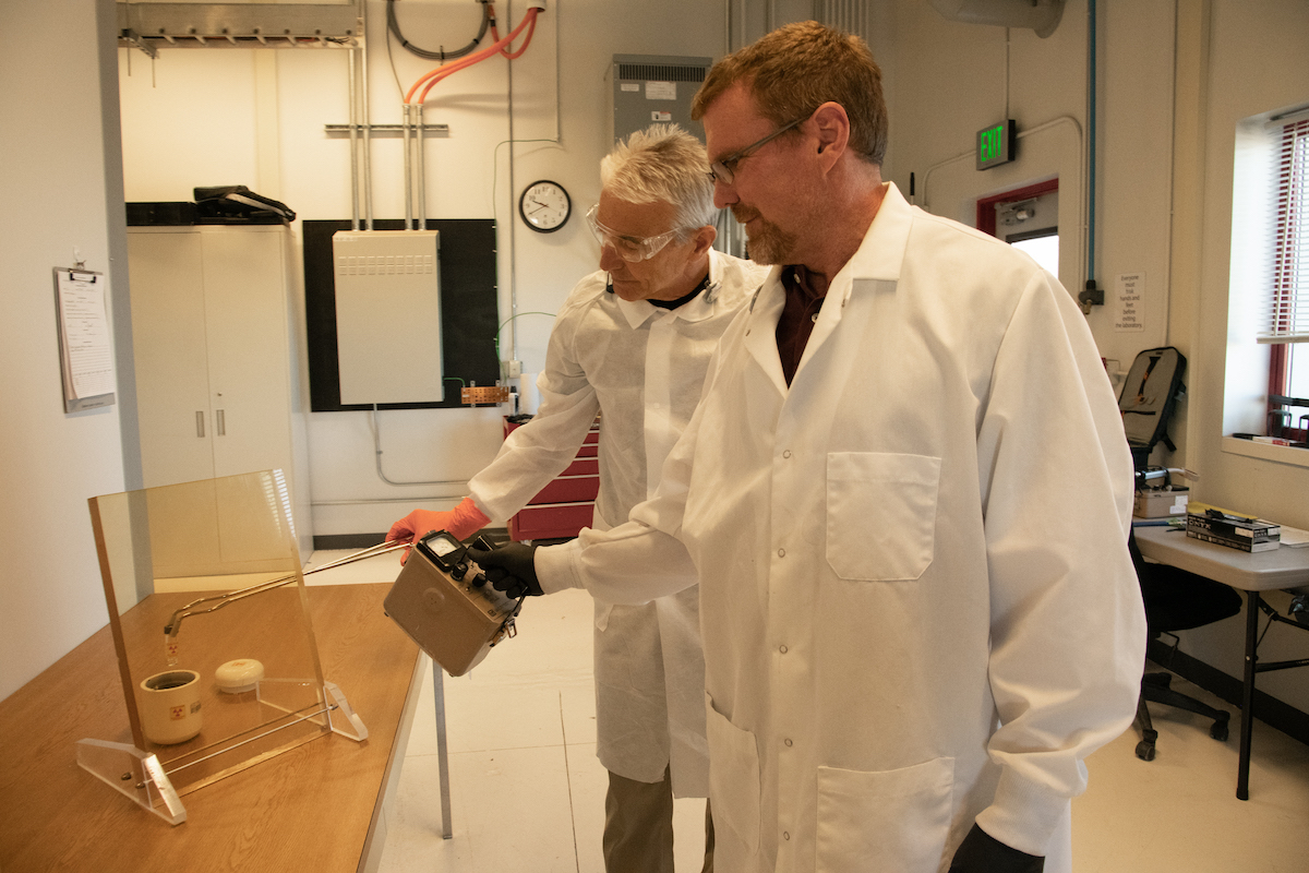 Jon Stoner, lAC directer, left, and John Longley, radiation safety officer, are shown loading a sample of the medical isotope copper-67 into a container for shipment.