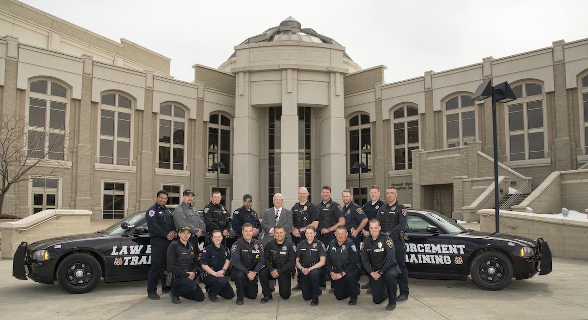 16 officers posed in front of Stephens Performing Arts Center