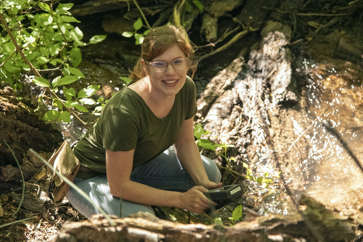 Alyssa DeSmit getting a water sample from Gibson Jack Creek