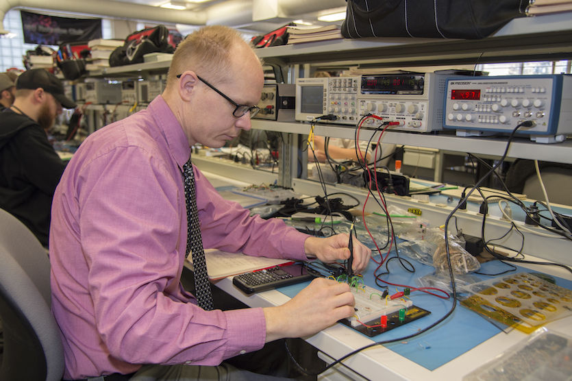 Photo of Christopher of Albano working on a circuit board.