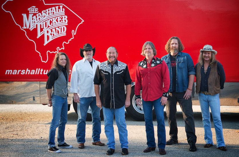 A photo of the Marshal Tucker Band's five members standing in front of a truck trailer.