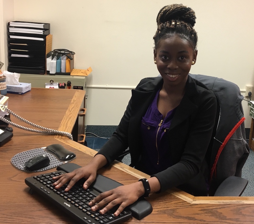 Photo of Paula Arinze at a desk typing.