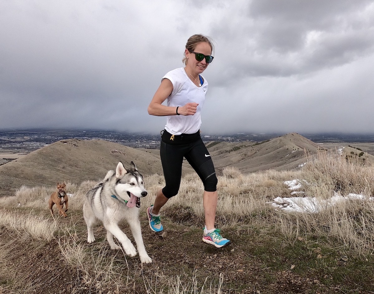 Peterson running on a trail with her dogs. 