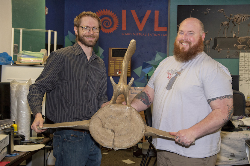Photo of Leif Tapanila and Jesse Pruitt of the IVL holding a large vertebrae of a whale. 