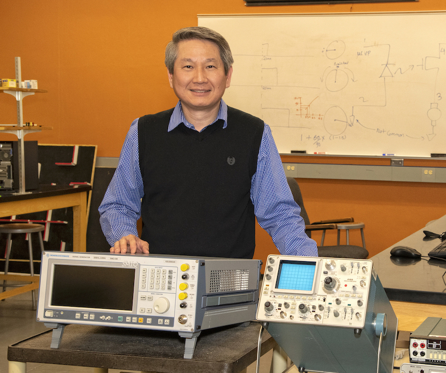 Steve Chiu standing next to electrical engineering equipment.
