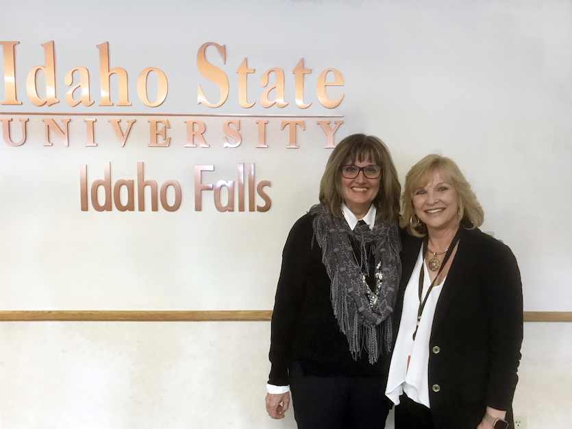 Photo of Ann Howell an Jennifer Fisher in front of ISU Idaho Falls sign at Bennion Student Union
