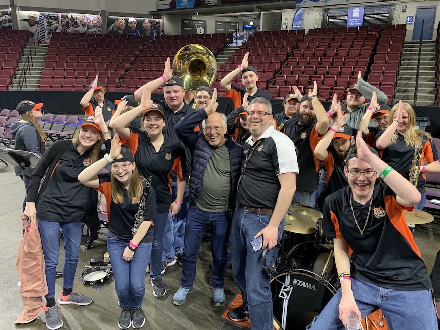 Photo of ISU Pep Band surrounding Jimmy Buffett and Tom Kloss.