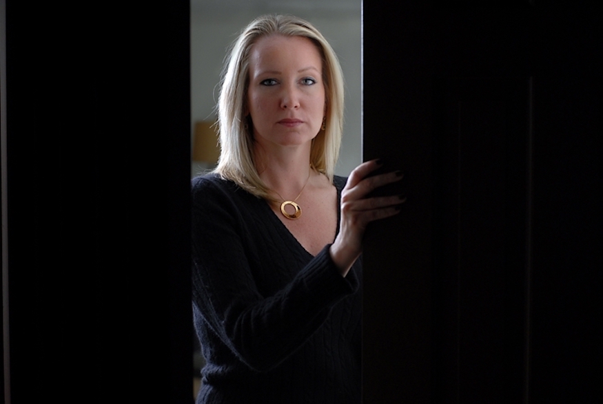 Photo of Liz Seccuro peering out a door.