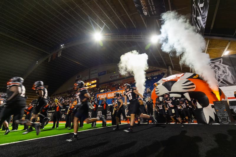 Football team running onto the field at Holt Arena