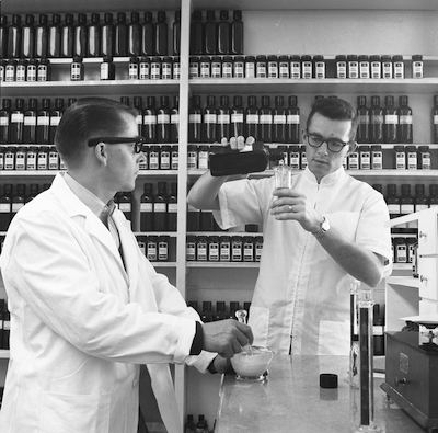 Historical College of Pharmacy photo with two males mixing medicines. 