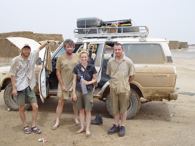 Four of team of researchers, including Tapanila, posing in front of a Landrover.