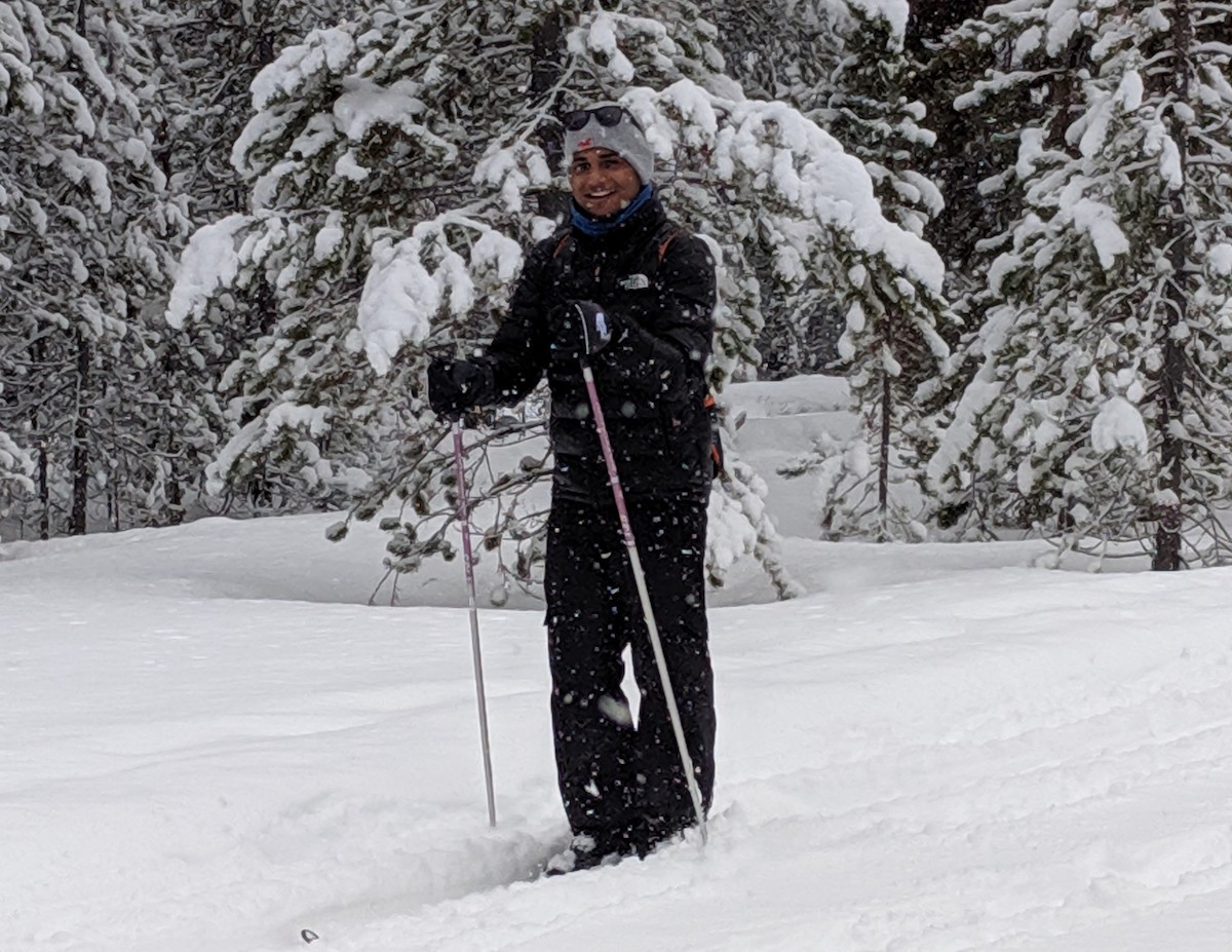Student cross-country skiing in snowy setting. 