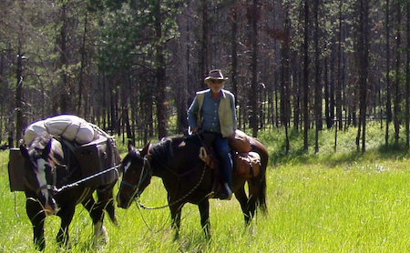 Minshall on riding a horse leading another pack horse