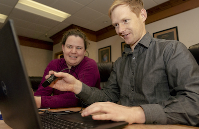 A resident, working on a computer, receiving training.