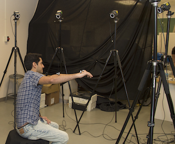 Photo of student with sensors on his arm to cameras can track movement.