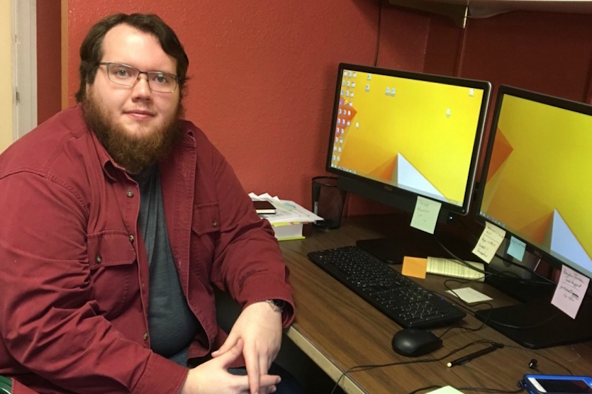 Photo of Jerimiah Phillips sitting by a computer.