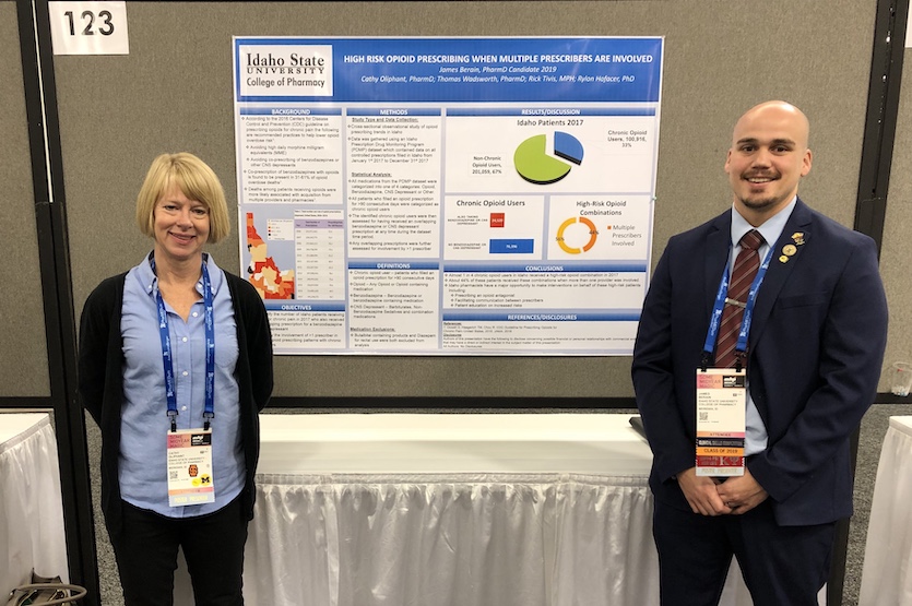 Photo of Oliphant and Berian standing in front of their research poster.