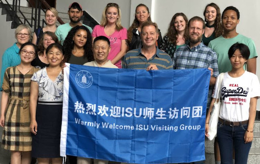 Photo of some of ISU contingent in China with a banner and some of their hosts.