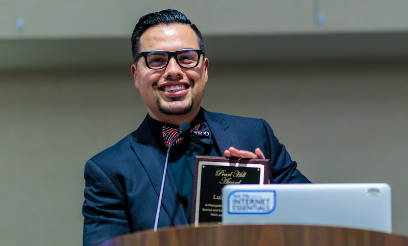  Luis Carrillo with his award at a podium.