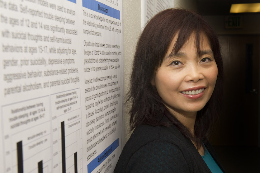 Maria Wong posing in front of research poster.