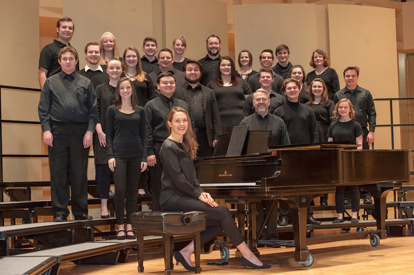 Photo of ISU Chamber Choir on stage dressed in black with its accompanist. 