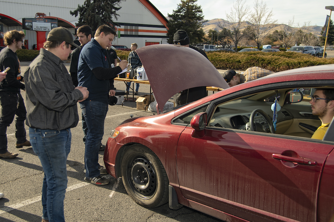 Student gets car worked on by volunteers.