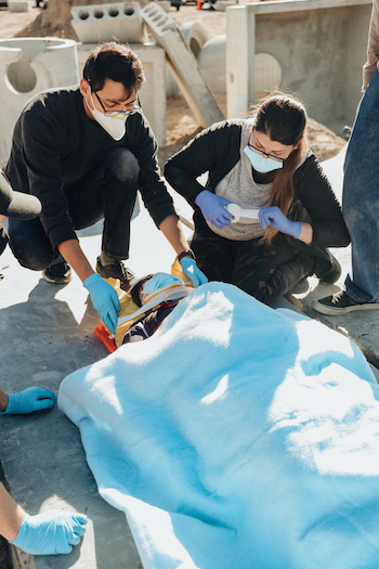 Two students working on person in a stretcher.