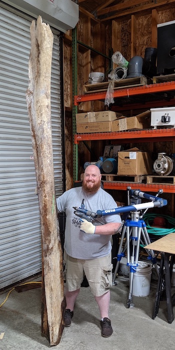 Jesse Pruitt with large whale bone the is double his height.