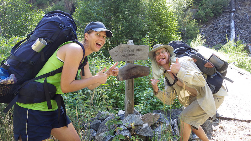 Mirijam Scharer and Adam Eckersell enjoying a silly moment at a trail marker on the Big Creek Trail.