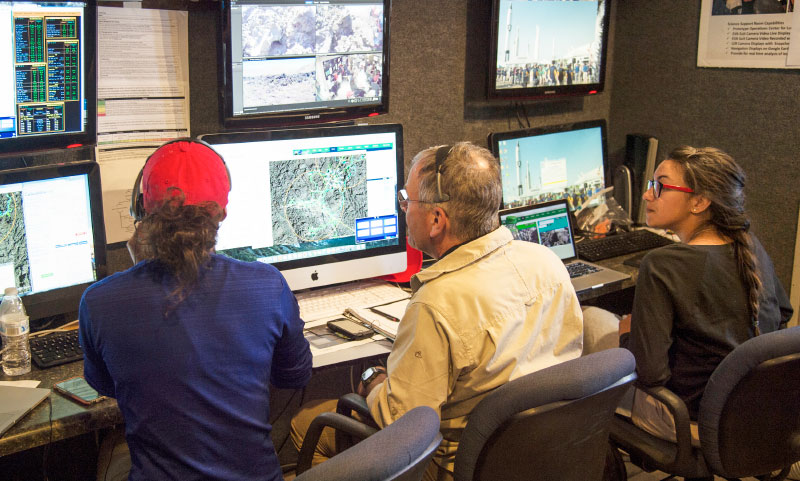 NASA’s Kara Beaton and Rick Elphic, and participating high school student Chanel Vidal monitor computer screens in NASA’s Mobile Mission Control Center that was set up in Arco this summer