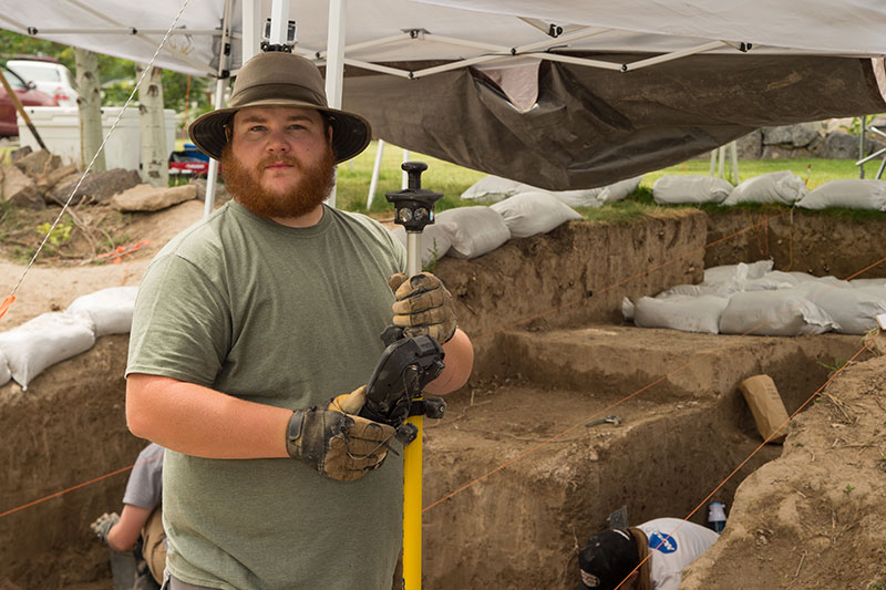 Student measuring dig area