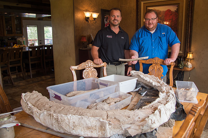 Professor and student showing mammoth bones