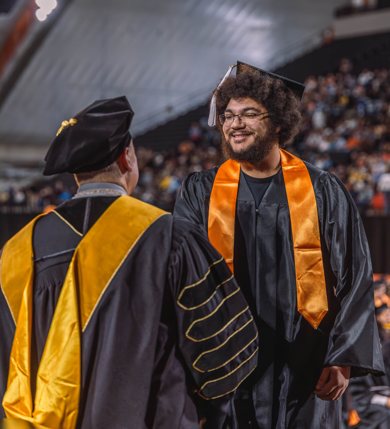Josh Govan shakes ISU President Robert Wagner's hand at commencement
