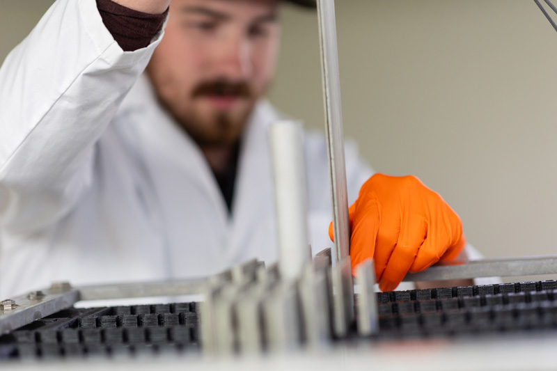 Idaho National Laboratory employee Braden Walker inserts a uranium-235 fuel plate into ISU’s subcritical assembly.