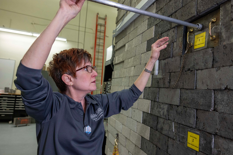 Mary Lou Dunzik-Gougar, professor of nuclear engineering, inserts the cadmium source into the reactor core of AGN-201, ISU’s on-campus nuclear reactor.