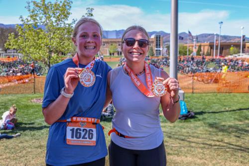Participants hold up their medals after crossing the finish line at the Bengal Triathlon