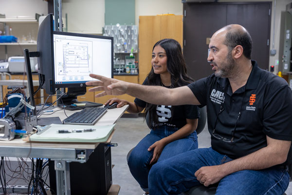 A student and Amir Ali, associate professor of nuclear engineering, pose for a photo at the Center for Advanced Energy Studies in Idaho Falls.
