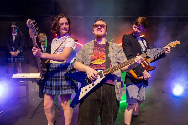 Actors with guitars in School of Rock performance