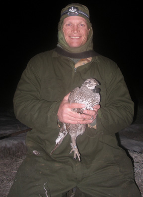 Peter Coates holds sage grouse with radio collar.