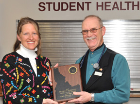 Paula Phelps, ISU PA program clinical director, hands ISU's Mike Doyle his PA Excellence Award.