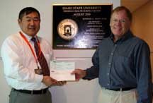 Joseph Han, ISU associate vice president for facilites, (left), and John Julian, Idaho Department of Public Works architect, display check.