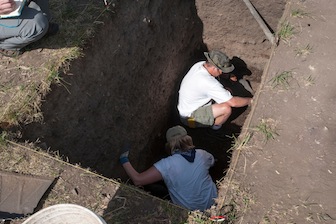 Amy Coughlin, bottom, and Jeff Castro excavate one of the test pits. (ISU Photographic Services)