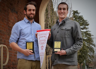 Brock Sondrup, left, and Patrick Loftus pose with their PKD awards under the Swanson Arch on ISU's campus.