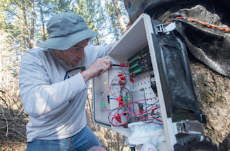 Student Dylan Refaey working on equipment at research sites that help measure plant transpiration rates. 