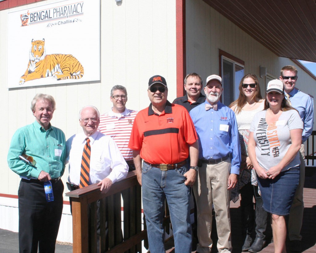 ISU President Arthur Vailas (center in orange shirt) and Bengal Pharmacy team at grand opening in Challis. From left: Gene Hoge, Arlo Luke, ISU Foundation; Rex Force, Bengal Pharmacy;  Kent Tingey, Advancement; Paul Cady, Emily Edwards, Carla Green, Chris Owens, College of Pharmacy.