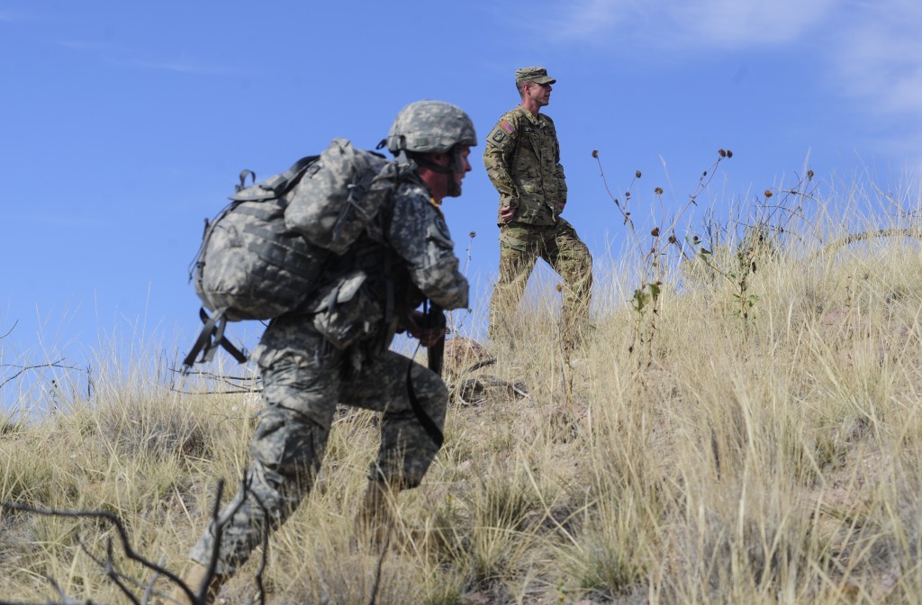 Cdt. Travis Holverson runs up a hill during a training exercise with Capt. Geoff Klein pictured in the background. 